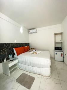 甘博阿Estrela Premium Pousada的一间卧室配有一张大床和一台小冰箱