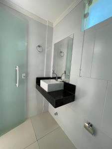 甘博阿Estrela Premium Pousada的白色的浴室设有水槽和镜子