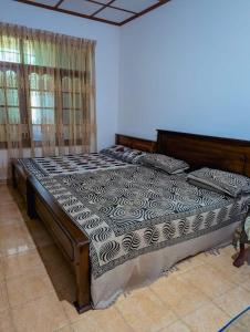 班德勒韦勒Katugaha Estate Bungalow的一间卧室配有一张木架床