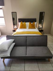 约翰内斯堡No Loadshedding Fast WiFi Lux Apartment的一间卧室配有一张带黄色枕头的大床