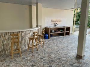 圣玛尔塔EL PARAISO DE GAIRA的厨房配有带椅子和柜台的酒吧