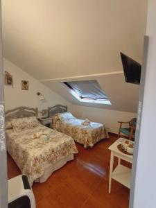 阿里纳斯·德·卡伯瑞勒斯Apartamentos y Habitaciones El Coterin的一间卧室配有两张床和电视。