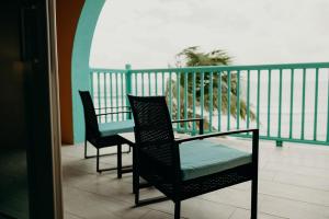 克里斯琴斯特德Grapetree Bay Hotel and Villas的阳台配有2把椅子和1张桌子