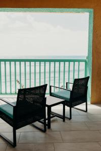 克里斯琴斯特德Grapetree Bay Hotel and Villas的阳台上配有两把椅子和一张玻璃桌