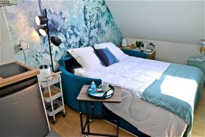亚眠Studio, centre ville, tout confort, local vélo的一间卧室配有一张带蓝色床头板的床和一张桌子