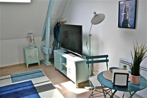 亚眠Studio, centre ville, tout confort, local vélo的客厅配有电视和桌子