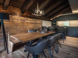 沃瑟姆阿尔伯格AlpenParks Hotel & Apartment Arlberg Warth mit Pool的一间带木桌和椅子的用餐室