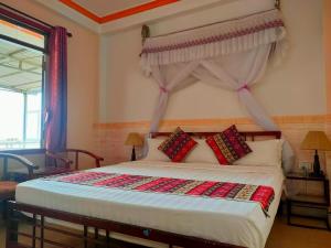 萨帕阮当住宿加早餐旅馆的一间卧室配有一张带天蓬的床