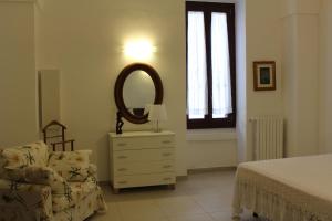 莱韦拉诺Il Melograno的一间卧室配有梳妆台、镜子和椅子