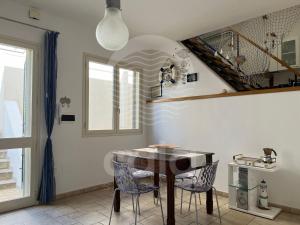 切萨雷奥港Il Timone的一间带桌椅和楼梯的用餐室