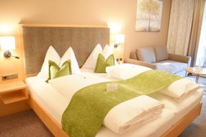 Eibiswald克鲁普菲客乐花园酒店的一间卧室配有一张带绿色和白色枕头的大床