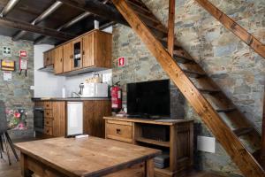 雷东多DieAna Alojamento Redondo的厨房配有木桌和电视。