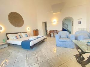 卡普里Suite Palazzo Capri - Seaview的一间卧室配有一张床、两把椅子和一张桌子