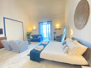 卡普里Suite Palazzo Capri - Seaview的一间大卧室,配有一张大床和蓝色的椅子