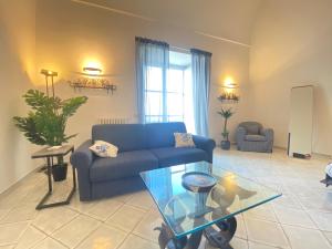 卡普里Suite Palazzo Capri - Seaview的客厅配有蓝色的沙发和玻璃桌