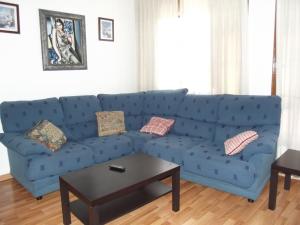 莱昂桑多瓦尔旅馆的客厅配有一张蓝色的沙发,配有一张桌子
