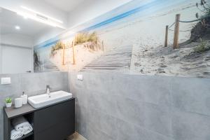 济夫努夫Dziwnówek Apartament Horizon Park 4A的一间带水槽和海滩壁画的浴室