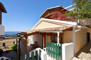 格利法达Two-bedroom Condo with Sea View in Glyfada的白色的房子,有绿色的围栏和鲜花