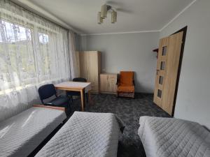穆希纳Agroturystyka Elżbieta i Juliusz的一间卧室配有两张床、一张桌子和一张桌子