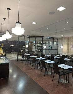 蒙得维的亚阿尔韦亚尔酒店的用餐室配有桌椅和灯光