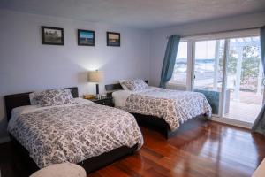 维多利亚HOV B&B House -Hospitality Ocean View Victoria-的一间带两张床的卧室和一个阳台