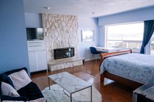 维多利亚HOV B&B House -Hospitality Ocean View Victoria-的一间卧室配有一张床和一个石头壁炉