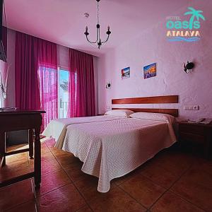 科尼尔-德拉弗龙特拉阿塔拉亚绿洲大酒店的卧室配有一张带粉红色墙壁的大床