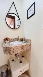 新彼得罗波利斯Cantinho Paz e Amor的浴室设有水槽和墙上的镜子