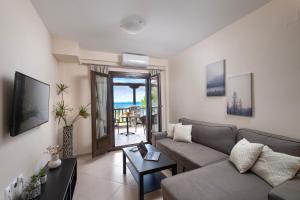 科罗皮Iakovakis Seaside Exclusive Apartments的客厅配有沙发和桌子