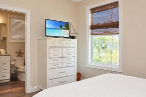 Cape San BlasSearenity by Pristine Properties Vacation Rentals的一间卧室配有梳妆台,楼上配有电视