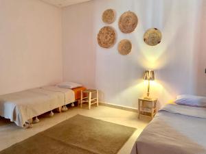 塔姆拉赫特乌兹达尔Ocean Surf House的一间设有两张床和一盏墙上灯的房间