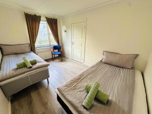 诺尔雪平Nyrenoverat 2-våningshus的一间卧室设有两张单人床和一个窗户。