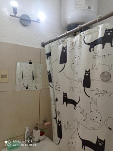 蒙得维的亚Habitación privada en apto cat friendly的浴室设有淋浴帘,上面有猫