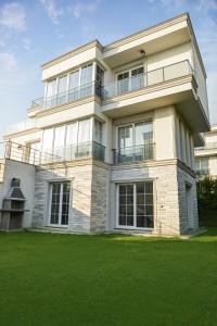 大切克梅杰Nora Marmara Luxury Villas in Istanbul的前面有绿色草坪的大建筑