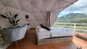 昆达桑Syameen's Glamping Dome的一间卧室设有一张床和一个大窗户