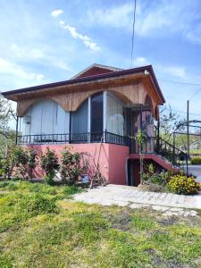 HAS Bağ Evi的一间位于街道上的带阳台的粉红色小房子