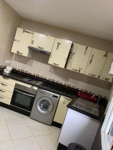 Apartamentos Palace Rif Al Hoceima的厨房配有洗衣机和墙上的箱子