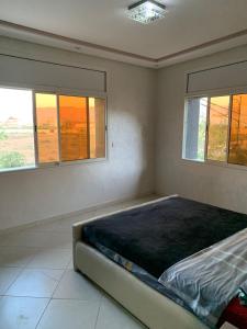 Apartamentos Palace Rif Al Hoceima的配有2扇窗户的客房内的1张床