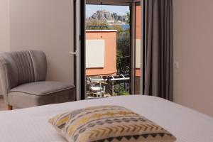 科孚镇Corfu Town Luxury Studio -C的卧室配有床、椅子和窗户。