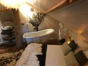 Les Portes du CoglaisLes Cabanes de Koad'dour - séjour SPA dans les arbres的带浴缸、沙发和沙发的浴室