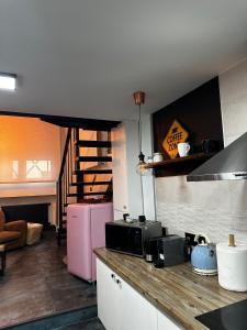马德里T-Homes - Cuenca的厨房配有柜台和粉红色冰箱