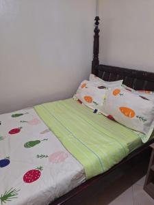 恩德培OKRA HOUSE的一张床上有水果和蔬菜枕头
