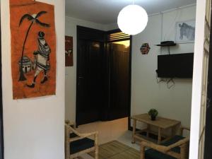 恩德培OKRA HOUSE的客厅配有桌子和墙上的绘画