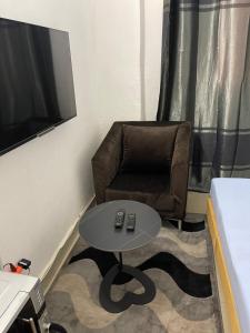 巴马科Appartement Studio Damou的一间带椅子和桌子的房间以及一台电视
