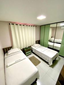 博阿维斯塔Residencial renaissance的酒店客房,设有两张床和镜子