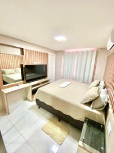 博阿维斯塔Residencial renaissance的一间卧室配有一张床和一台平面电视