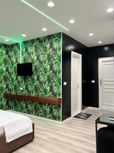 费里Hotel MoonLight的一间卧室,墙上贴着绿色的绿叶壁纸