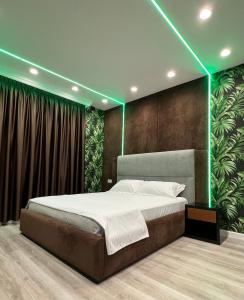 费里Hotel MoonLight的一间卧室配有一张绿灯大床