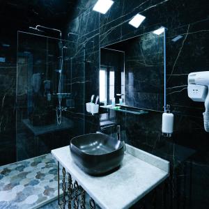 巴库Avrasya Hotel的黑色浴室设有水槽和淋浴