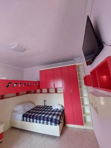 地拉那GEX Guest House的一间卧室设有红色橱柜和天花板上的电视。